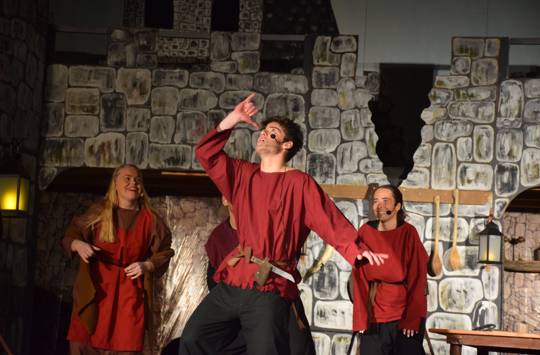 En efterskoleelev spiller en røver i Ronja Røverdatter, som danser til røversangen mens et par andre ser på