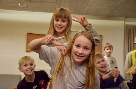 Glade børn smiler og laver V tegn med fingrene på Sædding Efterskole til årets Funpark