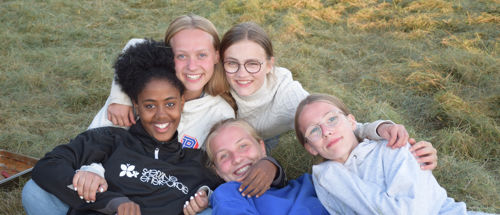 Ledige jobs på Sædding Efterskole. Her ses fem piger fra Sædding Efterskole, som ligger sammen i græsset og smiler til kameraet.