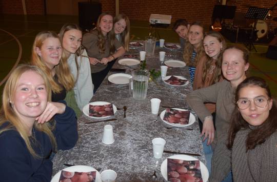En flok efterskolepiger sidder ved et julepyntet bord til juleafslutningen på Sædding Efterskole