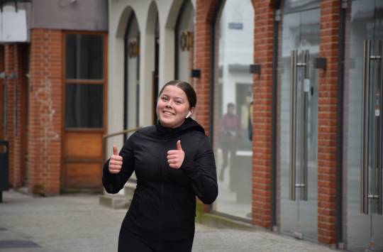 En pige fra Sædding Efterskole giver thumbs up, mens hun løber halvmarathon i Holstebro bymidte